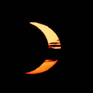 Éclipse solaire à 20 h 40 — le croissant traverse les nuages